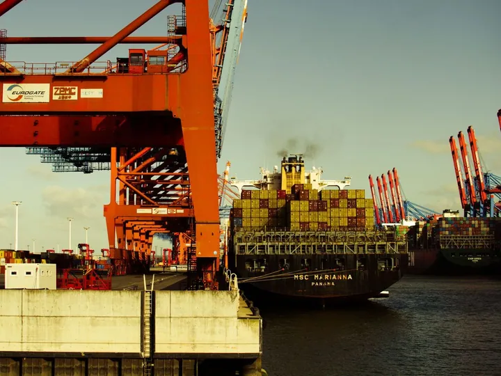 Container ship beside port cranes during cargo handling