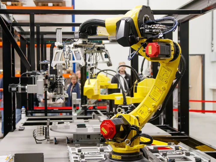 Yellow industrial robot arm working in a manufacturing facility